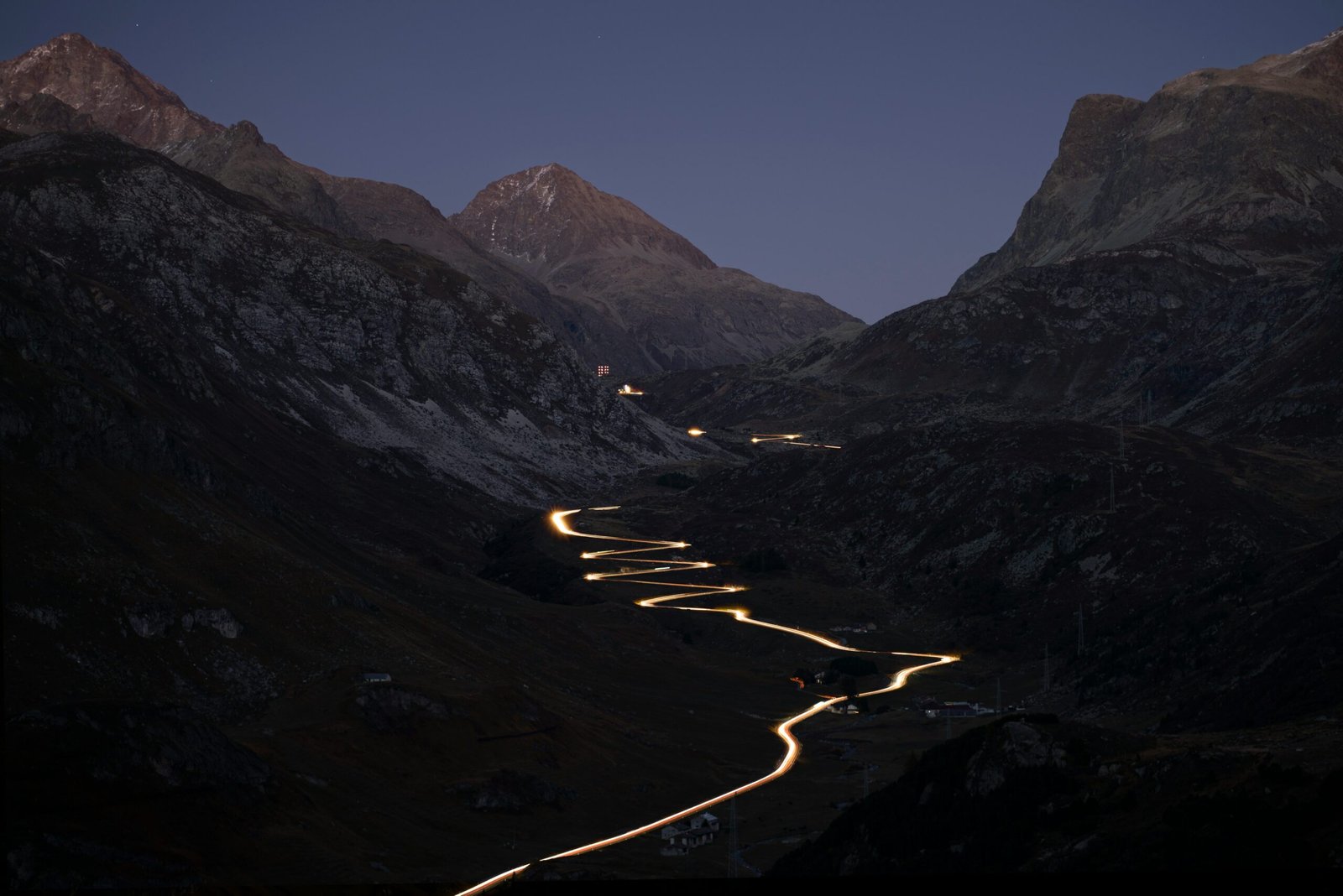 Light trails of cars winding up an Alpine pass at dusk, Switzerland